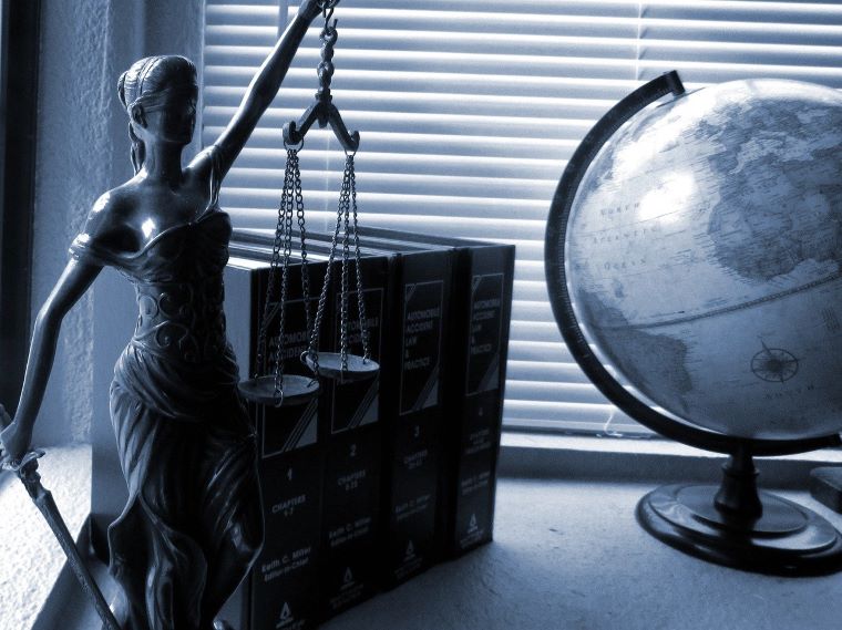 Ilustračný obrázok: soška bohyne Justície, zbierky zákonov, glóbus. Zdroj: Pixabay.com