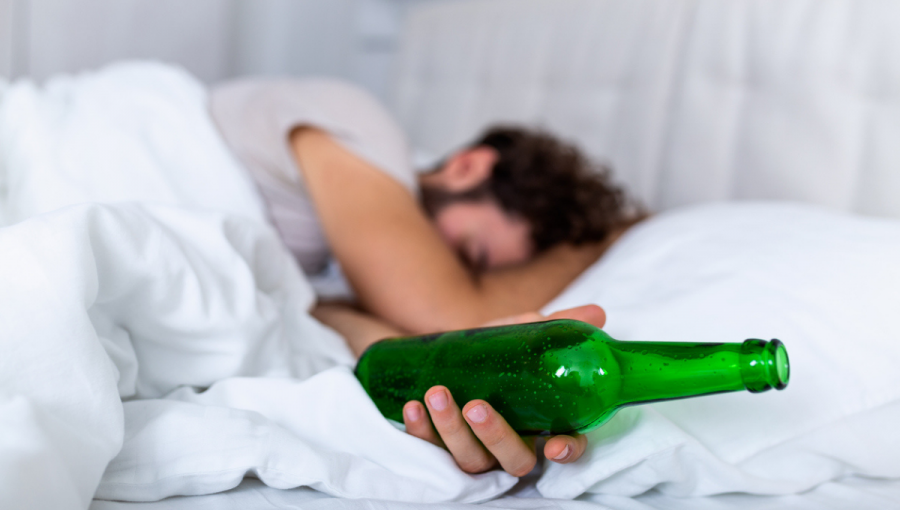 Muž s fľaškou v posteli. Zdroj: iStockphoto.com