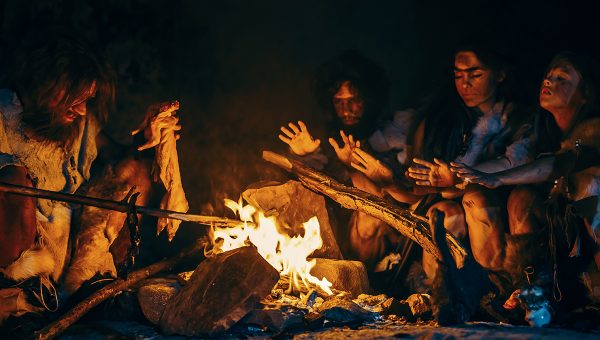 Pravekí ľudia pri ohni v jaskyni. Zdroj: iStockphoto.com
