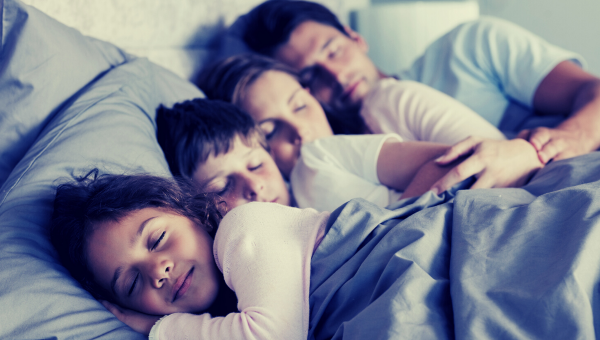 Dve deti a rodičia spia v posteli. Zdroj: iStockphoto.com