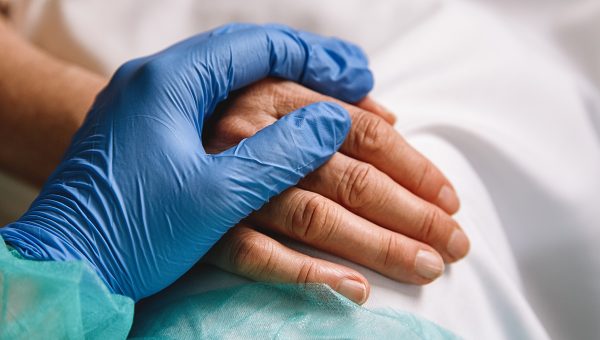 Zdravotník drží za ruku pacienta. Zdroj: iStockphoto.com