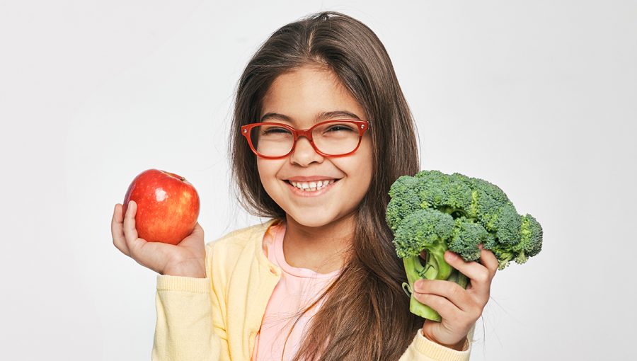 Dievča držiace jablko a brokolicu. Zdravé vegetariánske jedlo pre deti. Zdroj: iStockphoto.com