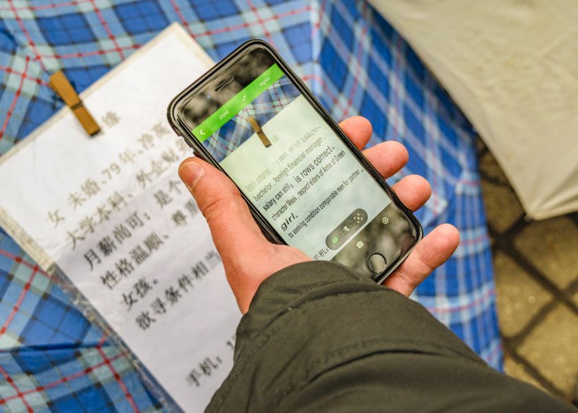 Foto zobrazuje ako pomocou funkcie Google Prekladač muž smartfónom prekladá čínštinu do angličtiny. Zdroj: iStockphoto.com