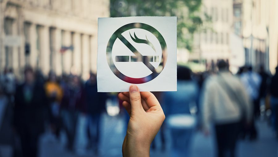 Znak zákazu fajčenia na pozadí zaľudnenej ulice. Zdroj: iStockphoto.com