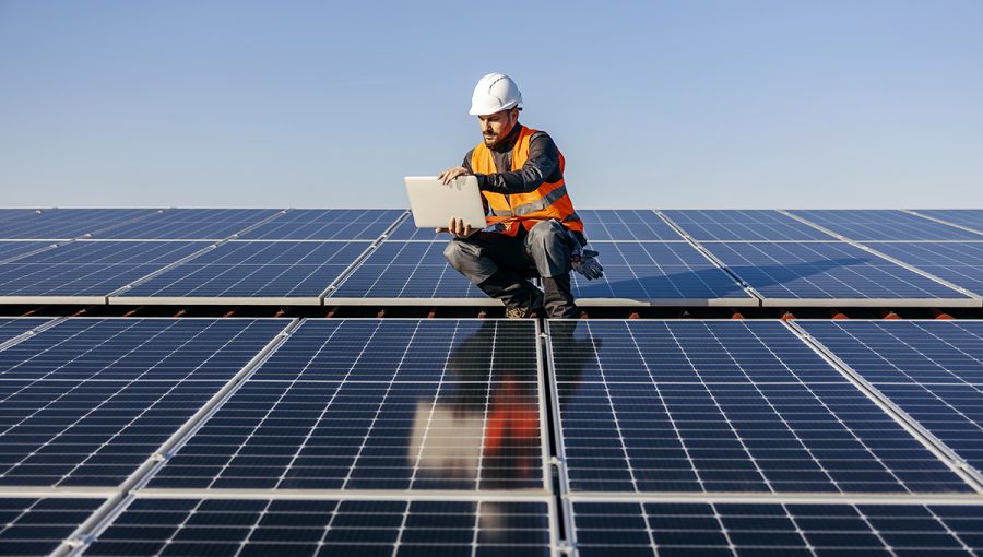 Inžinier na streche so solárnymi panelmi. Zdroj: iStockphoto.com