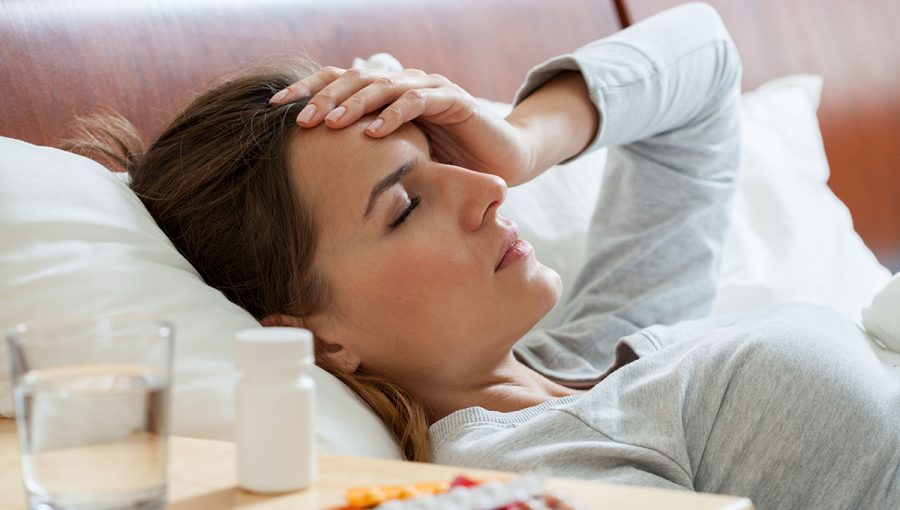 Žena leží doma s bolesťou hlavy. Zdroj: iStockphoto.com