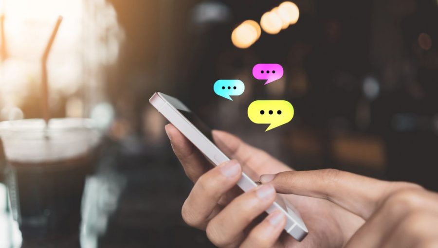 Obrázok, na ktorom sú ruky a mobilný telefón, nad ktorým s vznášajú chatovacie bubliny ilustruje komunikáciu prostredníctvom sociálnych sietí a internetu. Zdroj: iStockphoto.com
