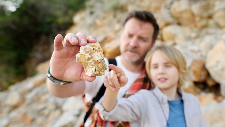 Otec a syn si na turistike prezerajú horniny. Zdroj: iStockphoto.com