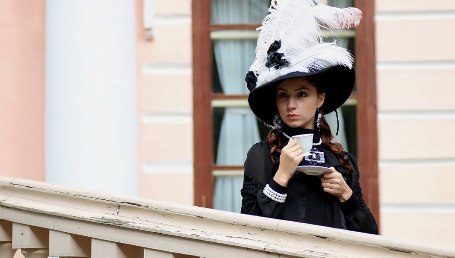 Žena v dobových šatách a klobúku s perím. Zdroj: iStockphoto.com
