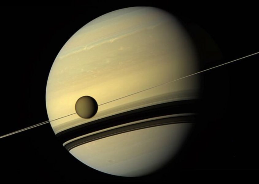 Titan pred diskom svojej planéty Saturn.
