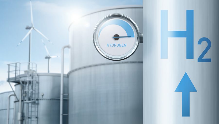 Vodíkové potrubie s meradlom na pozadí továrne využívajúcej obnoviteľnú energiu. Zdroj: iStockphoto.com