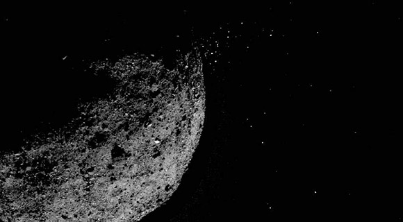 (5) Pohľad na asteroid Bennu, z povrchu ktorého unikajú pevné častice. Výsledná snímka bola získaná kombináciou krátkej expozície asteroidu a dlhej expozície jeho okolia z 19. januára 2019.