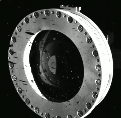 (8) Obrázok nasnímaný kamerou SamCam sondy OSIRIS-Rex z 22. októbra 2020 ukazuje hlavu zberača vzoriek plnú skál a prachu, zhromaždeného na povrchu asteroidu Bennu, a únik menších častíc.