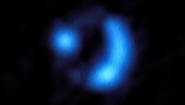 Obrázok ukazuje orientáciu magnetického poľa vo vzdialenej galaxii 9io9, ktorá je tu viditeľná v čase, keď vesmír mal len 20 % svojho súčasného veku. Ide o doteraz najvzdialenejšiu detekciu magnetického poľa galaxie.