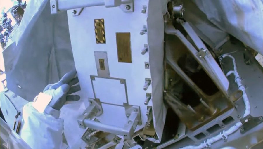 Pohľad z kamery namontovanej na prilbe skafandra. Astronautka NASA Jasmin Moghbeliová odstraňuje izoláciu z elektronickej skrinky rádiofrekvenčnej skupiny (RFG). Zdroj: NASA TV