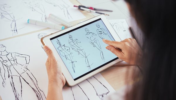 Kresby módnych návrhov na papieri a v tablete. Zdroj: iStockphoto.com