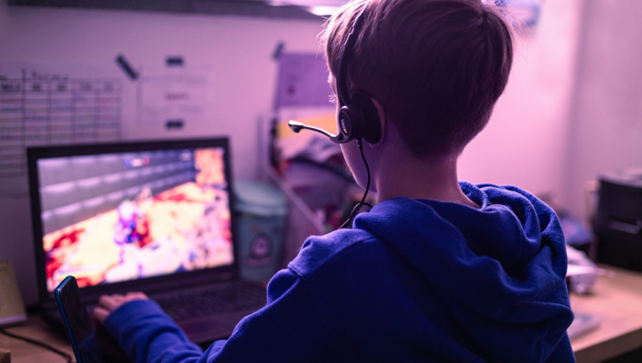 Chlapec so slúchadlami hrá počítačovú hru