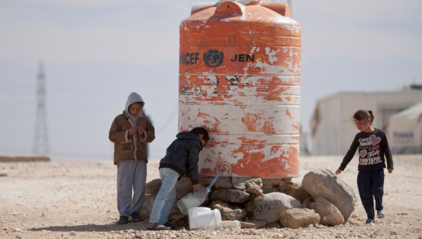 Deti naberajúce pitnú vodu do bandasiek v tábore pre sýrskych utečencov v Jordánsku.