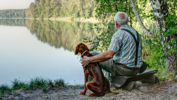 Starší muž a pes pri jazere