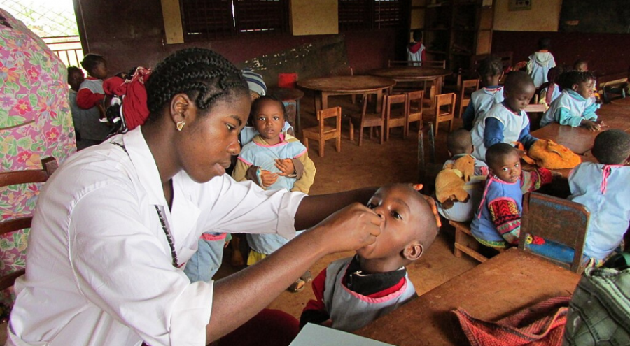 Očkovanie zodpovedá za viac ako 50 percentný pokles detskej úmrtnosti v Afrike. Pracovníčka z globálnej imunizačnej divízie CDC podáva orálnu vakcínu proti poliomyelitíde deťom v škôlke v Nigérii, 2016. Zdroj: Wikimedia Commons. Autor: Louie Rosencrans/CDC