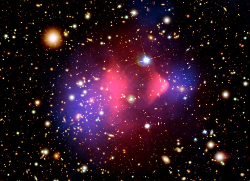 „Bullet cluster“ je dvojica galaktických kôp, ktoré sa čelne zrazili. Pri skúmaní rozloženia celkovej hmoty prišli vedci s prevratným zistením. Zdroj: ESA
