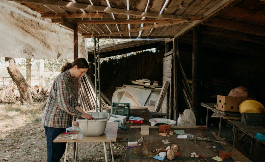 Účastník Letnej školy archeológie pri čistení nálezov.