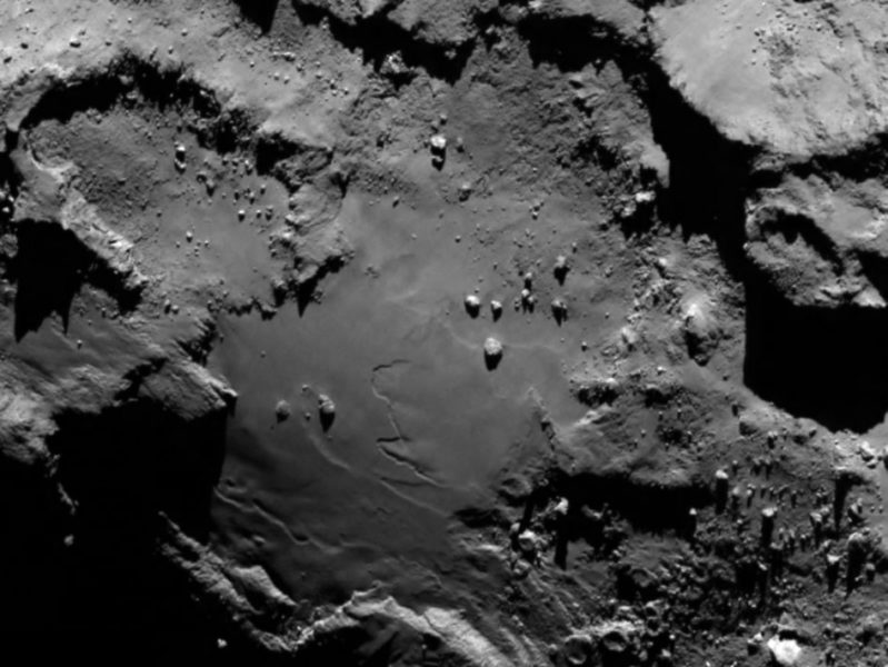 Snímka kométy 67P zhotovená kamerami OSIRIS. Zo vzdialenosti 130 km vidíme balvany, krátery a strmé útesy, rozlíšenie je 2,4 metra na pixel. Zdroj: ESA, MPS a OSIRIS tím