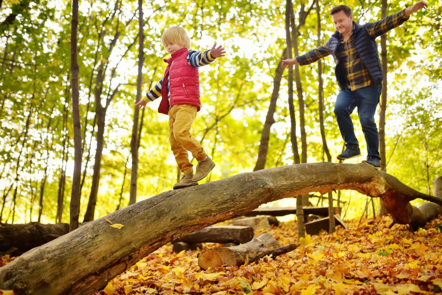 Otec s dieťaťom balansujú na kmeni stromu. Zdroj: iStockphotos.com. Autor: SbytovaMN