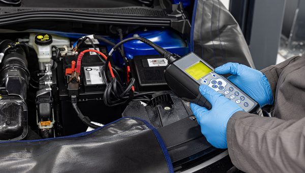 Automechanik testuje autobatériu. Zdroj: iStock.com/asikkk