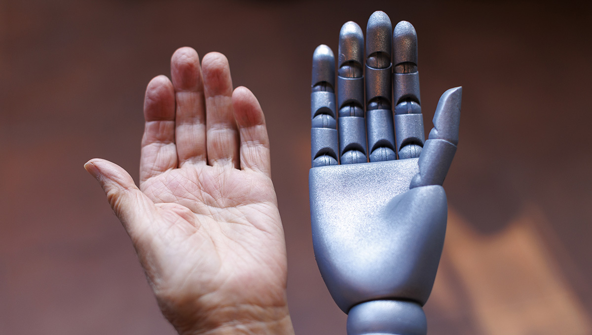 Ľudská a robotická ruka. Zdroj: iStock.com/aerogondo