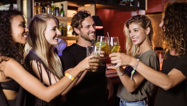 Mladí ľudia s drinkami v bare. Zdroj: iStock.com/Wavebreakmedia