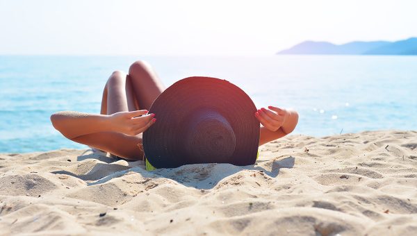 Žena sa opaľuje na pláži. Zdroj: iStock.com/Filipovic018