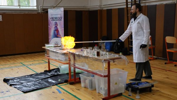 Muž predvádza chemické pokusy v telocvični