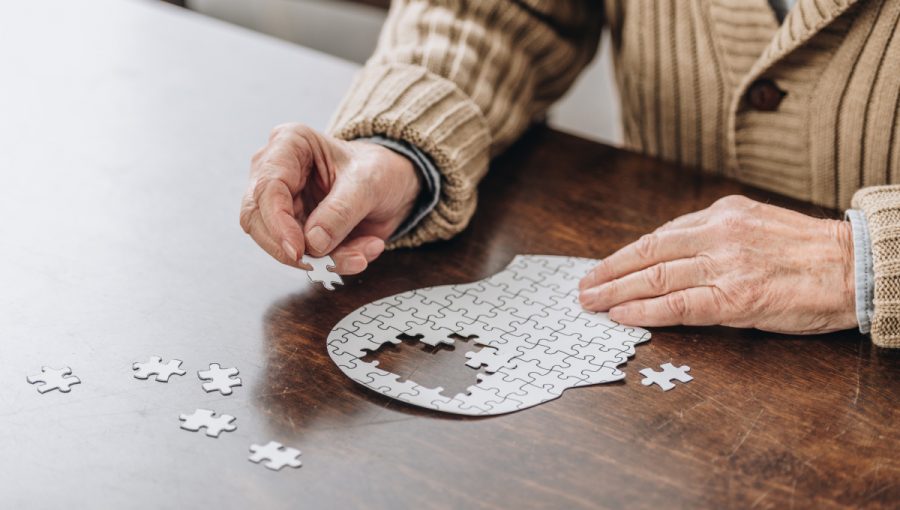 Starší muž skladá puzzle. Zdroj: iStock.com/LightFieldStudios