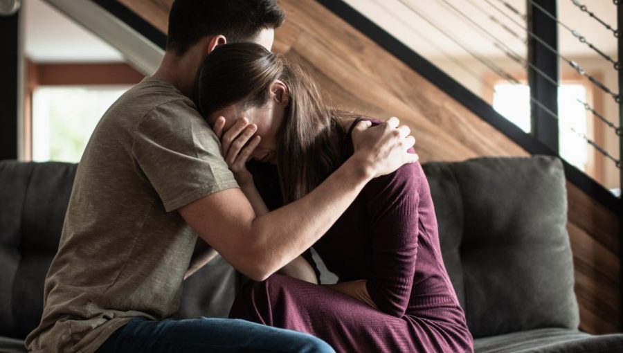 žena plače na pleci muža