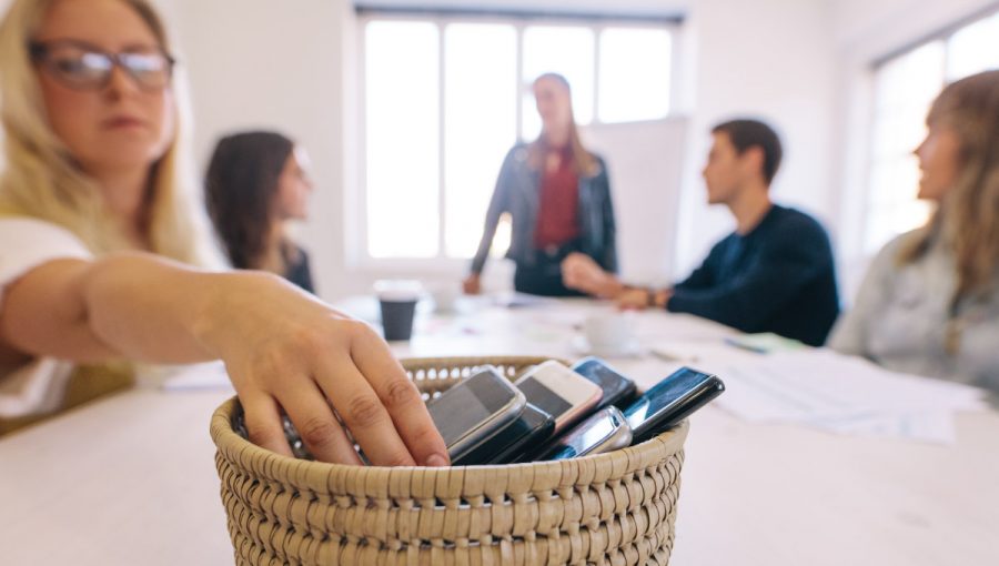 Odkladanie mobilov do košíka. Zdroj: iStock.com/jacoblund