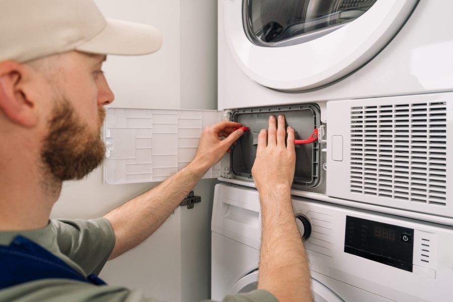 Technik vykonáva údržbu automatickej práčky. Zdroj: iStock/brizmaker