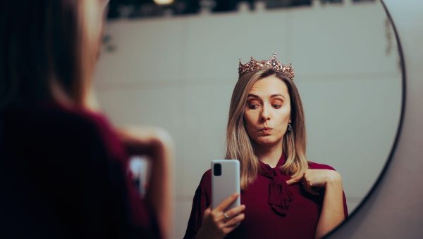 Žena pred zrkadlom obdivuje seba.