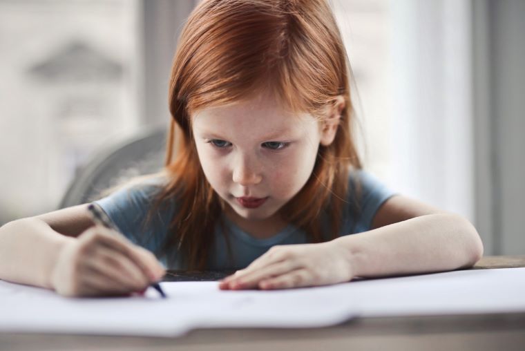 Ilustračné foto: Dievčatko píše do zošita. Zdroj: Pixabay.com
