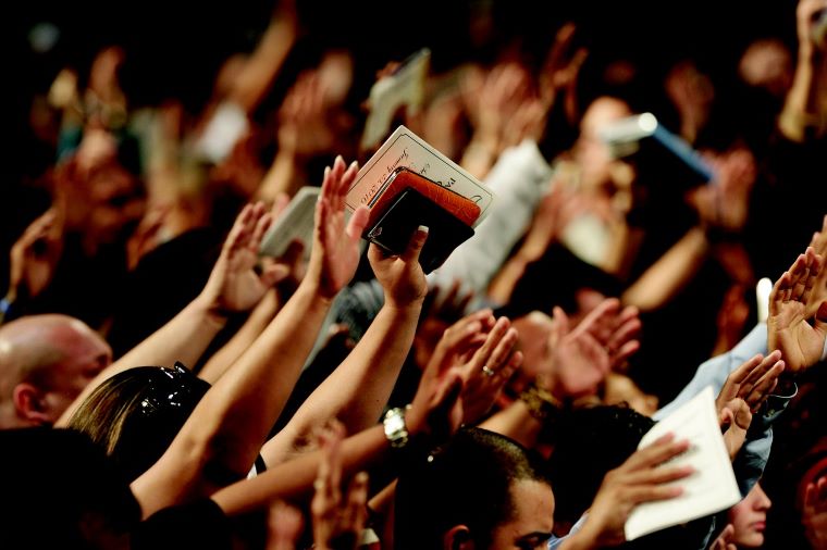 Ilustračné foto: Dav ľudí so zdvihnutými rukami, v ktorých držia Bibliu. Zdroj: pixabay.com