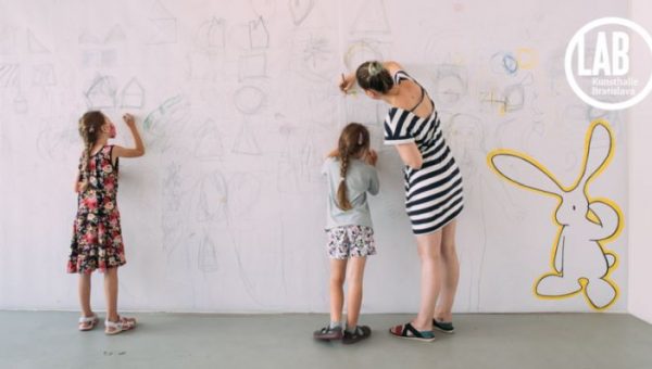 Na foto: Deti a žena kreslia na stenu. Zdroj: Kunsthalle Bratislava Zdroj: Kunsthalle Bratislava