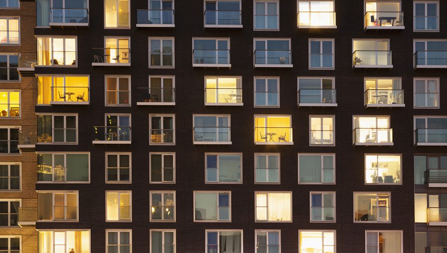 Ilustračné foto: Panelák v noci s rozsvietenými oknami. Zdroj: iStock
