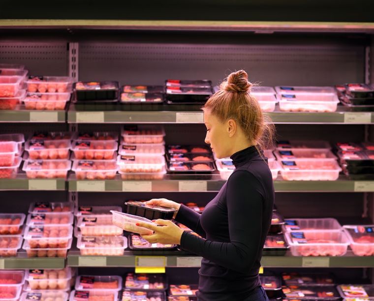 Ilustračné foto: Žena v supermarkete pred pultom s baleným mäsom. Zdroj: iStock 