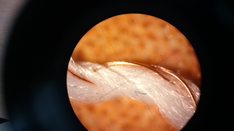 Mikroskopický pohľad na vodivé textilné vlákno.
