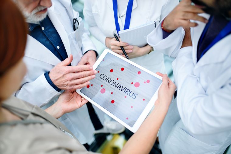 Ilustračné foto: Zdravotníci a vedci nad papierom s nápisom koronavírus. Zdroj: iStock